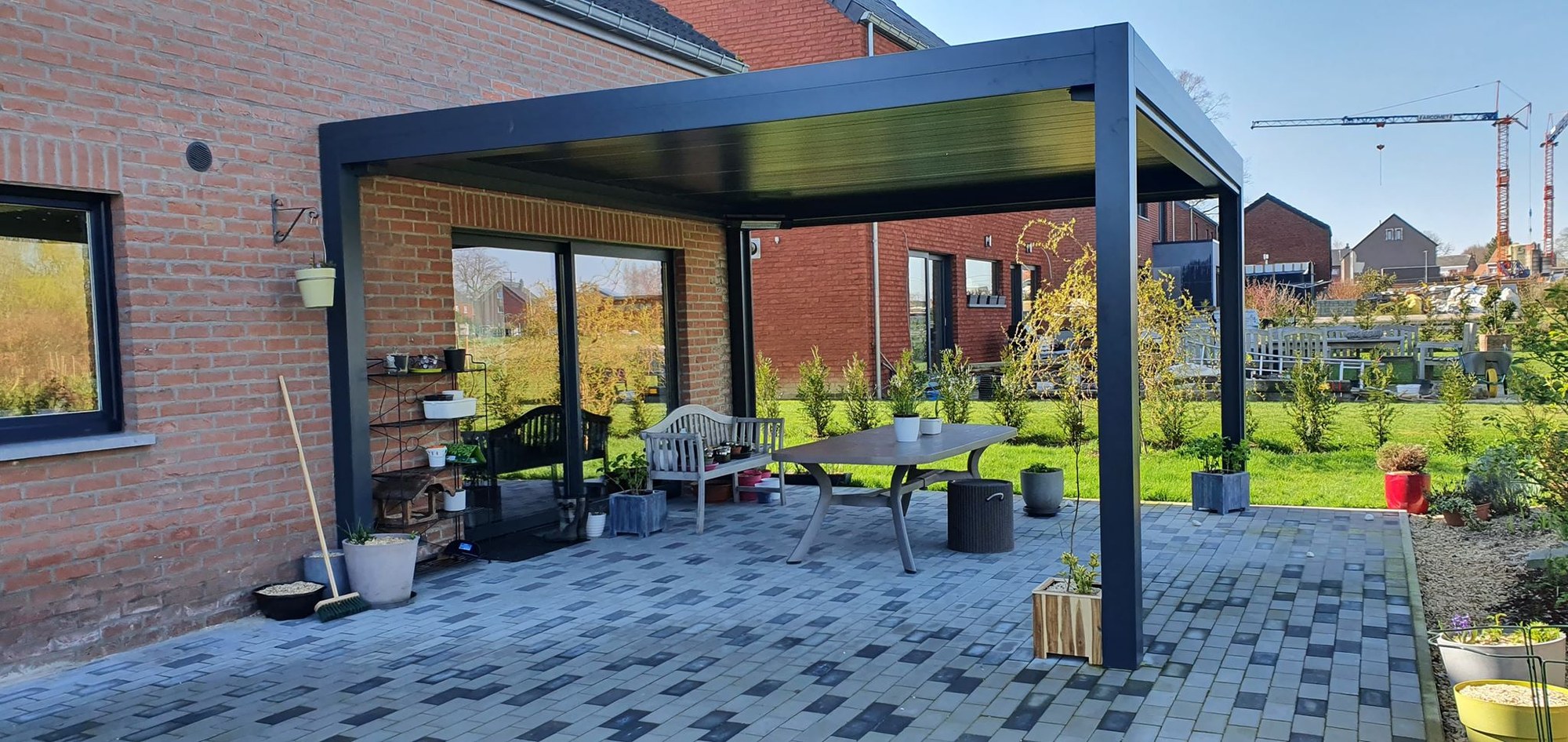 Pergola bioclimatique couvrant une longue terrasse pavée