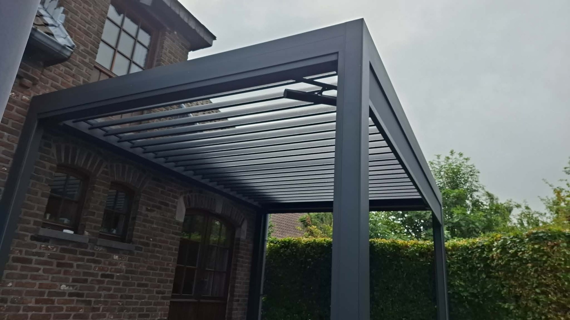 Pergola bioclimatique autoportante à lames orientables dans un jardin