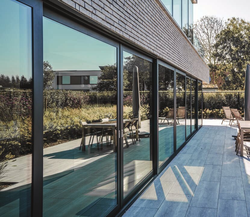 Baie coulissante Ultraglide ouverte sur une terrasse et une piscine