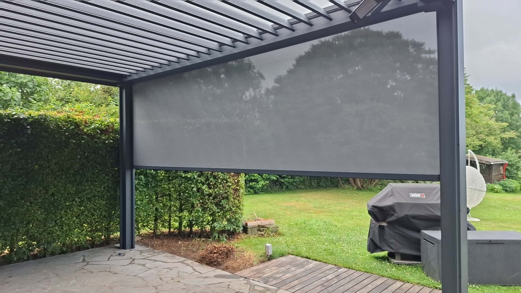 Pergola à lames avec screen vertical déployé face au jardin