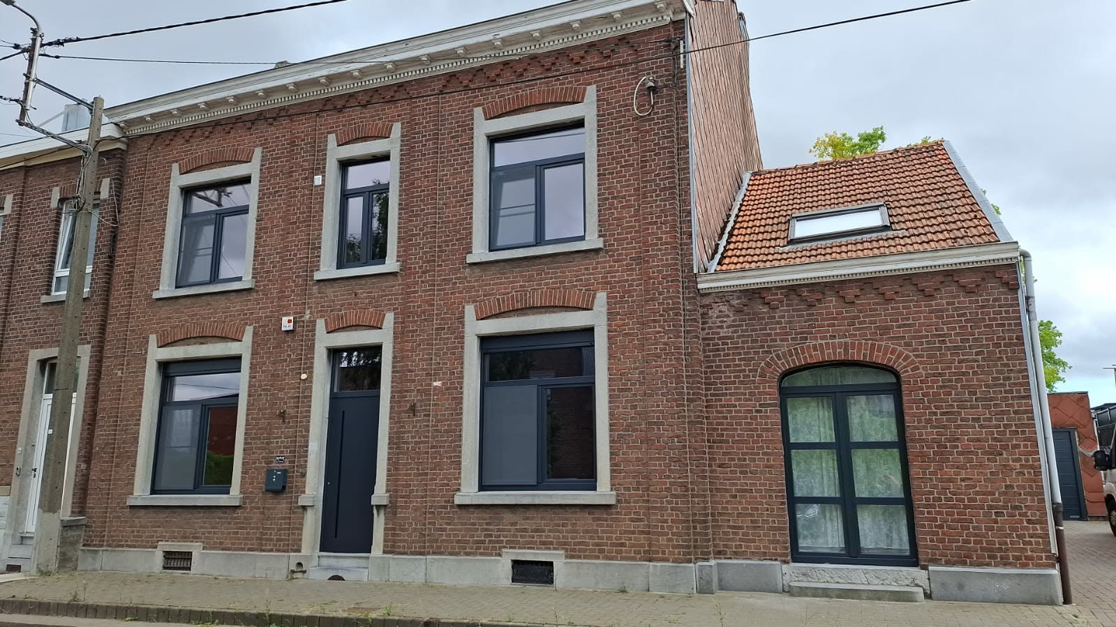 Maison de ville en brique avec châssis anthracite et soubassement en pierre bleue