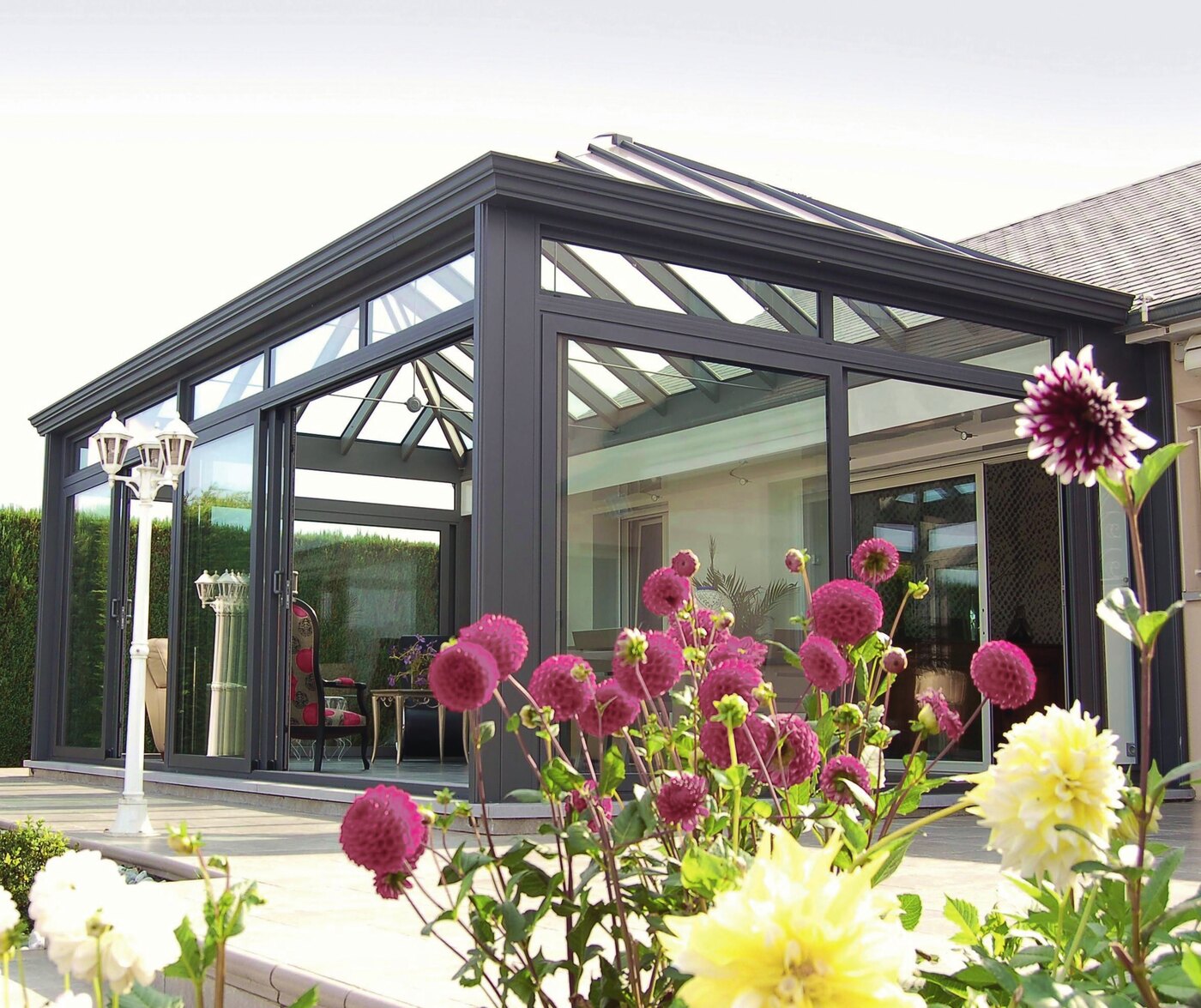 Véranda VR2000 à toiture vitrée en pavillon, vue depuis le jardin fleuri