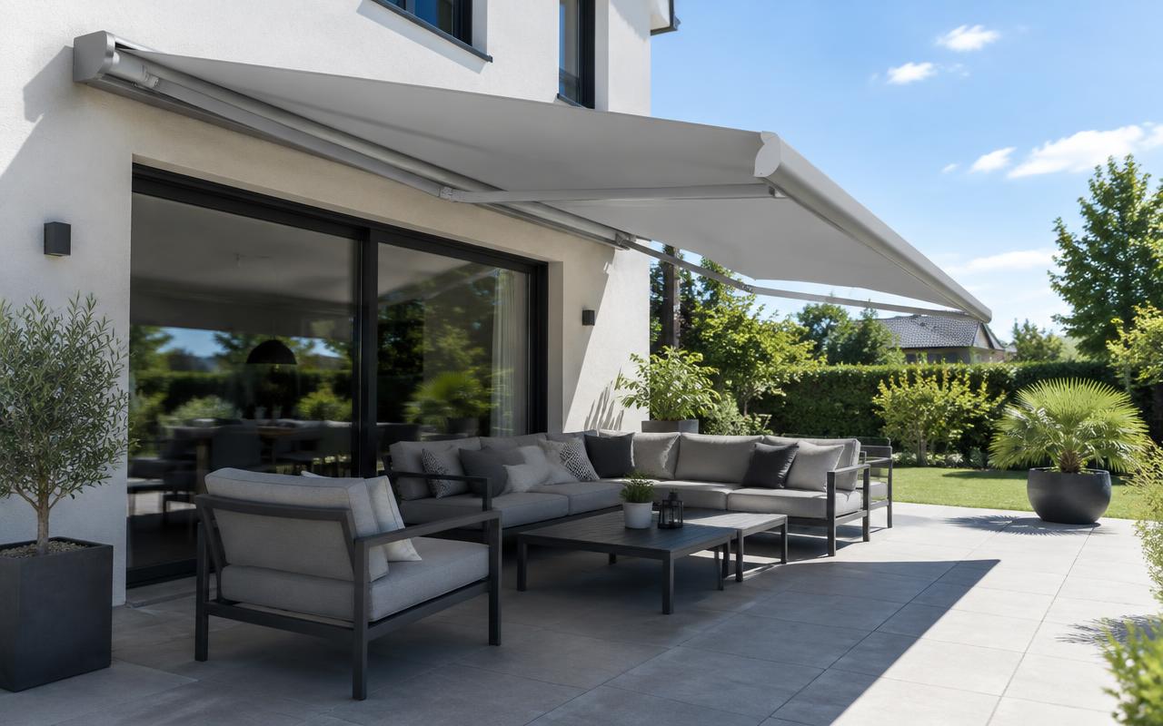 Banne solaire à coffre intégral gris clair déployée sur une terrasse